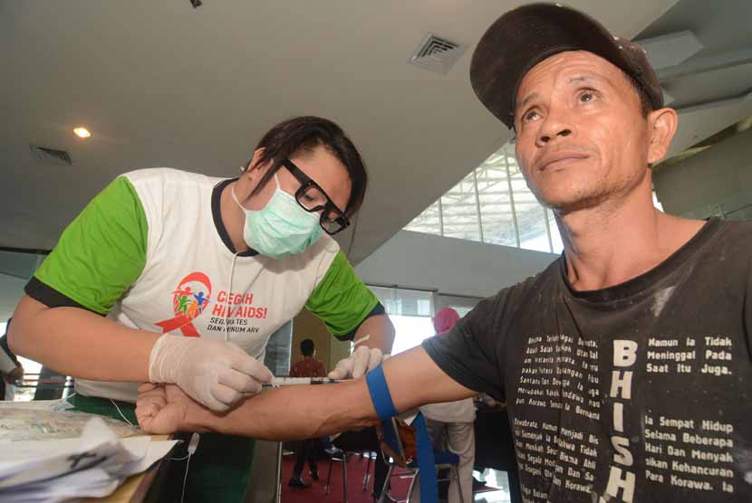 Petugas mengambil sampel darah seorang warga untuk diperiksa terkait pencegahan HIV/AIDS di Palu, Sulawesi Tengah, Senin (1/12). 