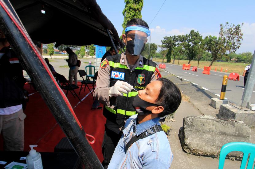 Petugas mengambil sampel dari pengendara yang mengikuti tes cepat antigen di posko penyekatan Susukan, Cirebon, Jawa Barat, Sabtu (15/5/2021).