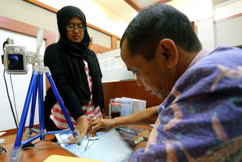 Petugas mengambil sidik jari pemohon paspor di Kantor Imigrasi Klas II Blitar, Jawa Timur, Kamis (24/3).