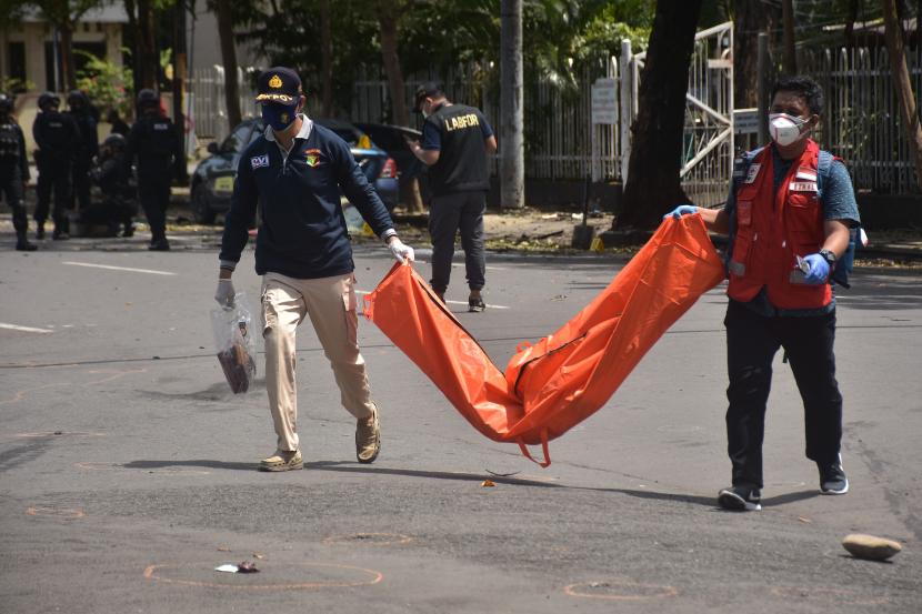 Petugas mengangkat kantong jenazah berisi bagian tubuh dari terduga pelaku bom bunuh diri di depan Gereja Katedral Makassar, Sulawesi Selatan, Ahad (28/3/2021). Bagian tubuh jenazah tersebut selanjutnya dibawa ke Rumah Sakit Bhayangkara Makassar untuk diidentifikasi. 