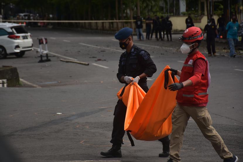 Petugas mengangkat kantong jenazah berisi bagian tubuh dari terduga pelaku bom bunuh diri di depan Gereja Katedral Makassar, Sulawesi Selatan, Ahad (28/3/2021). Bagian tubuh jenazah tersebut selanjutnya dibawa ke Rumah Sakit Bhayangkara Makassar untuk diidentifikasi.