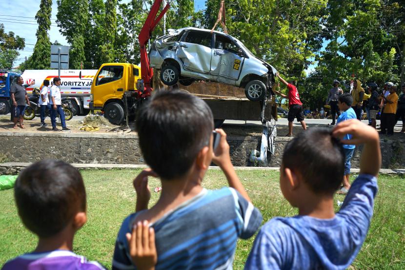 Petugas mengangkat mobil yang terperosok ke dalam selokan di jl Pangeran Hidayat, di Kota Gorontalo, Gorontalo, Senin (23/5/2022). Kecelakaan tersebut diakibatkan pengemudi yang mengantuk, sehingga menabrak pohon dan masuk ke dalam selokan, tidak ada korban jiwa dalam kecelakaan tunggal itu. 
