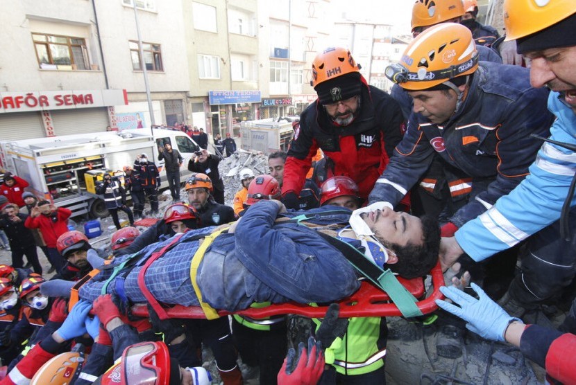 Petugas mengangkat seorang korban selamat yang ditemukan di antara reruntuhan bangunan usai gempa mengguncang Provinsi Elazig, Turki, Sabtu (25/1).