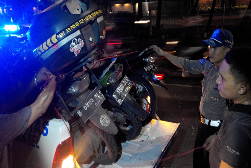 Petugas mengangkut motor korban tabrakan Metromini S 75 di Warung Buncit, Jakarta Selatan, Kamis (6/2) petang.