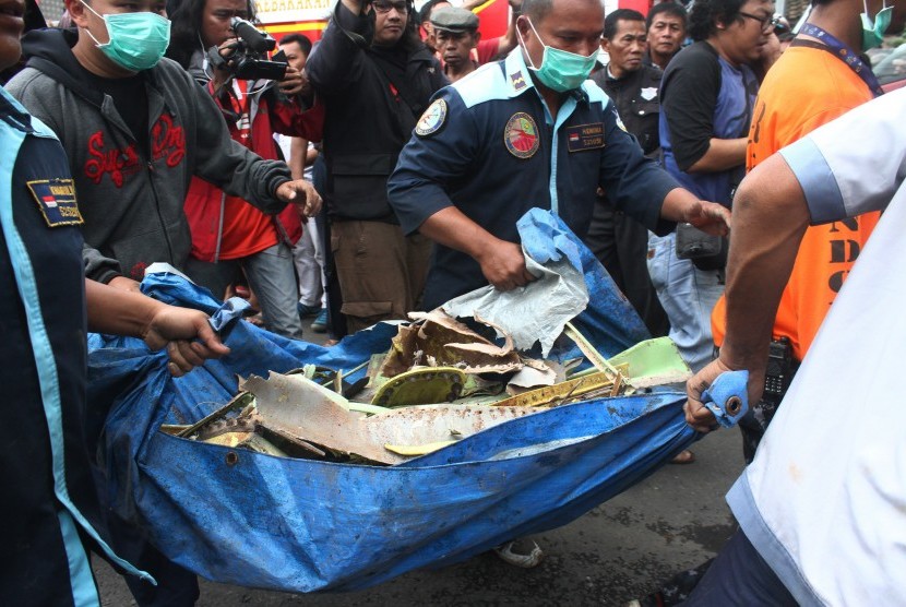 Petugas mengangkut puing-puing pesawat latih tempur Super Tucano yang jatuh di pemukiman warga di Jalan LA Sucipto, Malang, Jawa Timur, Rabu (10/2).  (Antara/Ari Bowo Sucipto))
