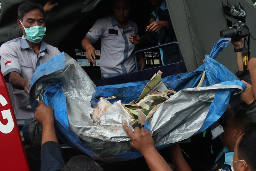 Petugas mengangkut puing-puing pesawat latih tempur Super Tucano yang jatuh di permukiman warga di Jalan LA Sucipto, Malang, Jawa Timur, Rabu (10/2).