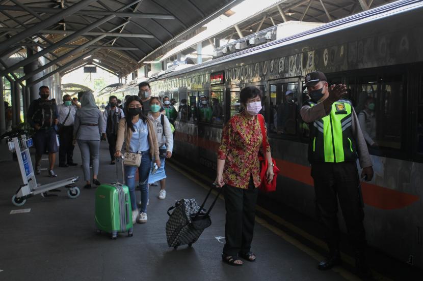 Petugas mengarahkan penumpang kereta api di Stasiun Gubeng, Surabaya, Jawa Timur.