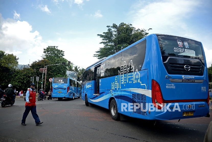  Petugas mengatur bus transjakarta koridor enam di lampu merah halte transjakarta Departemen Pertanian, Jakarta, Selasa (24/1).