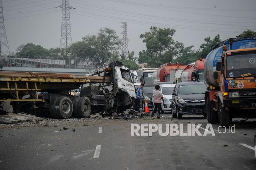Petugas mengatur lalu lintas di sekitar lokasi kecelakaan di kilometer 134 Jalan Tol Purbaleunyi di Pasir Koja, Bandung, Jawa Barat, Ahad (3/10/2021). Kecelakaan yang melibatkan sebuah truk pengangkut tiang bor, sebuah travel dan sebuah mobil keluarga tersebut masih dalam penyelidikan petugas. 