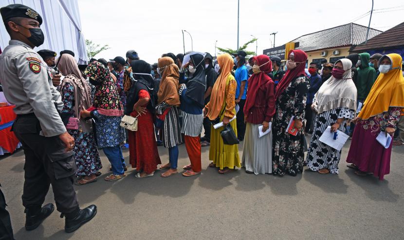 Petugas mengatur warga yang sedang antre saat acara Vaksinasl COVID-19 Secara Massal di Mapolres Kabupaten Serang, di Serang, Banten, Kamis (16/12/2021). Pemda setempat gencar menggelar vaksinasi COVID-19 secara massal dan serentak karena angka capaiannya baru 58 persen untuk mengejar target 70 persen - 90 persen guna mewujudkan kekebalan komunal (Herd Immunity).