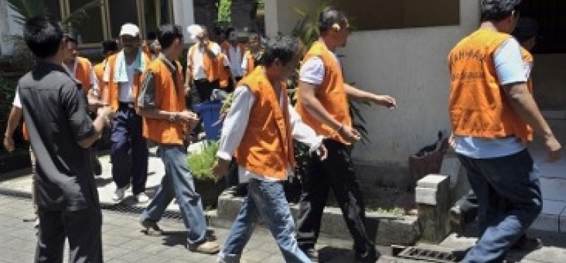 Petugas mengawasi sejumlah tahanan yang digiring dari Lembaga Pemasyarakatan (Lapas) Kerobokan untuk menjalani sidang di Pengadilan Negeri Denpasar, Bali, Senin (27/2). Aktifitas peradilan bagi tahanan yang dititipkan di Lapas terbesar di Bali itu mulai di