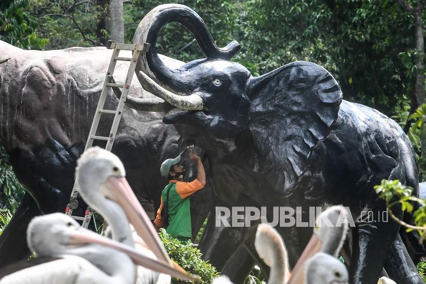 Petugas mengecat patung gajah di kandang Pelikan (pelecanus onocrotalus), Kebun Binatang Ragunan, Jakarta, beberapa waktu lalu.