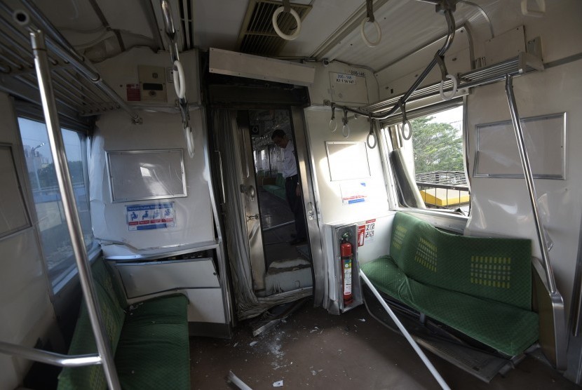 Petugas mengecek gerbong yang rusak akibat tabrakan Kereta Rel Listrik (KRL) di Stasiun Juanda, Rabu (23/9). 