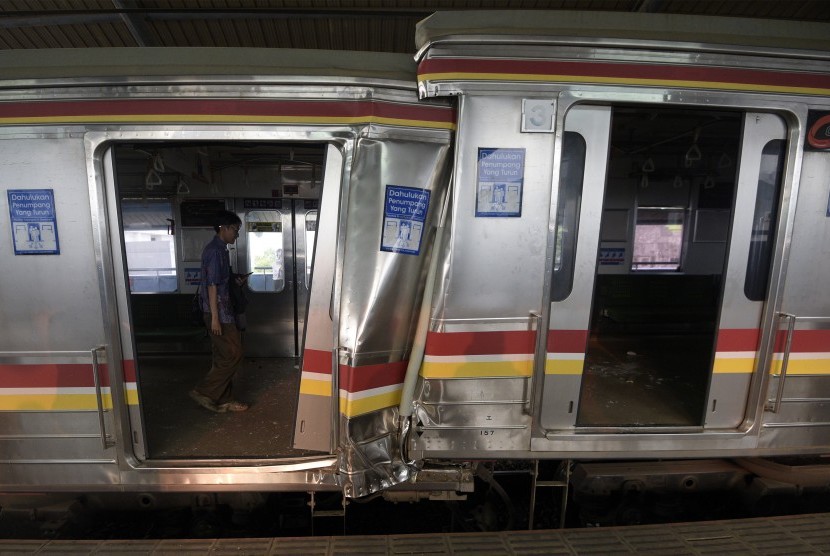 Petugas mengecek gerbong yang rusak akibat tabrakan Kereta Rel Listrik (KRL) di Stasiun Juanda, Rabu (23/9). 