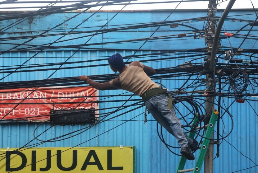 Petugas mengecek instalasi kabel di tiang listrik milik PLN di Benhil, Jakarta, Kamis (3/3).