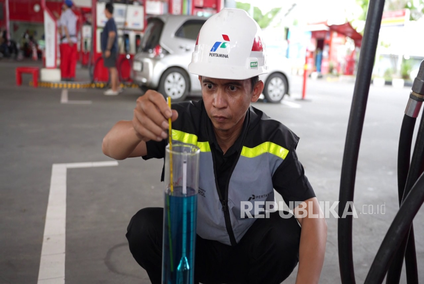 Petugas mengecek kualitas bahan bakar di sebuah SPBU.