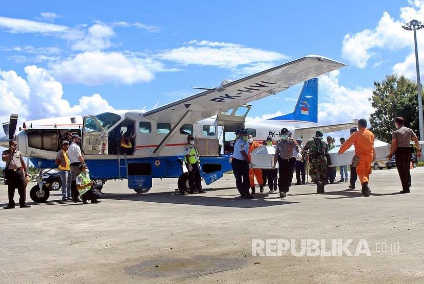 Petugas mengeluarkan jenazah korban jatuhnya pesawat Dimonim Air setibanya di Bandara Sentani, Kabupaten Jayapura, Papua, Senin (13/8).