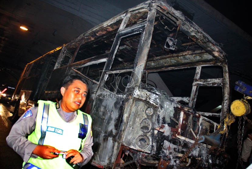  Petugas mengevakuasi bangkai Bus Transjakarta jurusan Blok M-Kota yang terbakar di Jl Jenderal Sudirman, tepat di bawah jembatan Semanggi, Jakarta, Senin (5/11) malam. (Yasin Habibi)