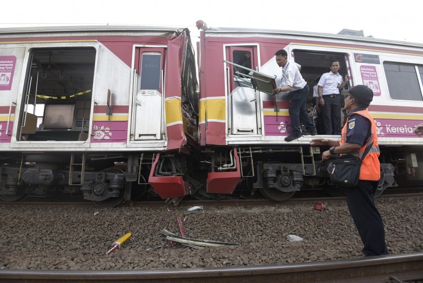 Petugas mengevakuasi barang barang yang ada di gerbong ketika terjadi tabrakan Kereta Rel Listrik (KRL) di Stasiun Juanda, Rabu (23/9).