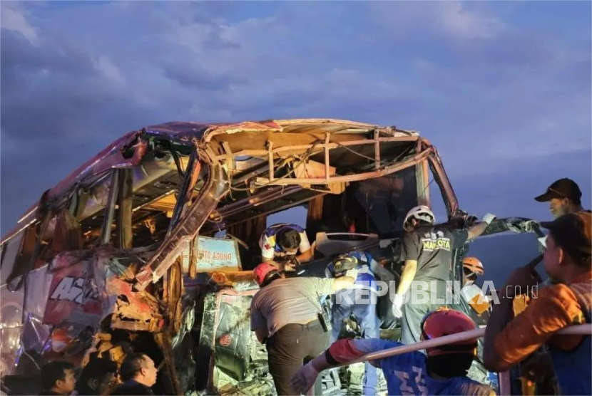 Petugas mengevakuasi bus yang mengalami kecelakaan di Kilometer (KM) 77+200 Tol Pandaan-Malang, Jawa Timur, Senin (23/12/2024).