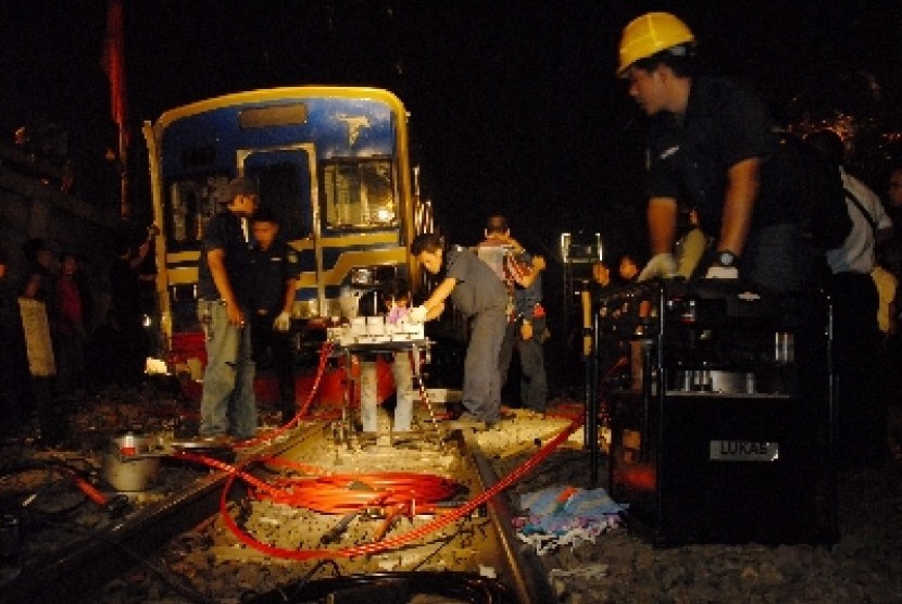 Petugas mengevakuasi kereta yang anjlok.