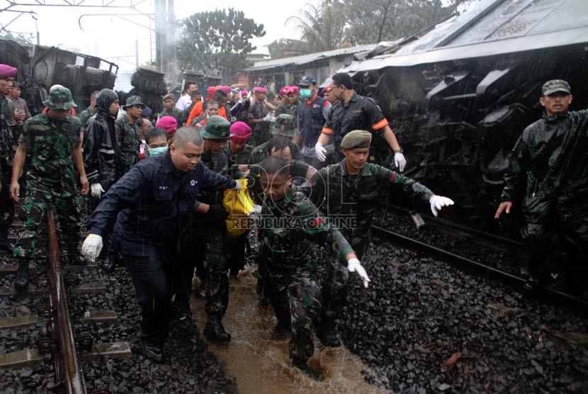  Petugas mengevakuasi korban kecelakaan kereta rel listrik di perlintasan kereta di Bintaro Permai, Tangerang, Senin (9/12).  (Republika/Yasin Habibi)