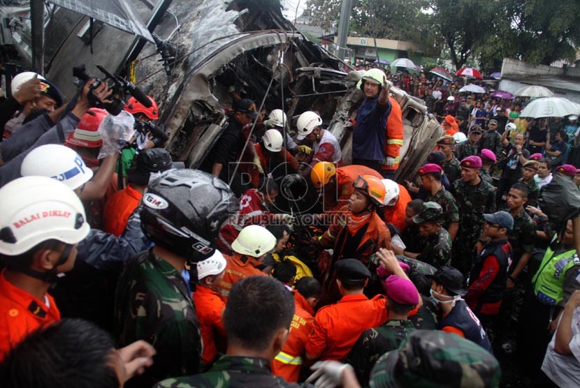 Petugas mengevakuasi korban kecelakaan kereta rel listrik di perlintasan kereta di Bintaro Permai, Tangerang Selatan, Senin (9/12). (Republika/Yasin Habibi)