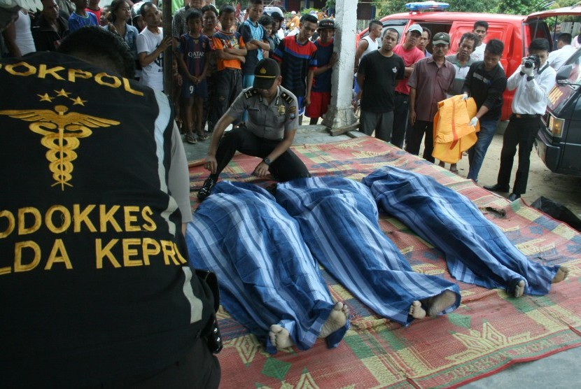 Petugas mengevakuasi korban meninggal tenggelamnya kapal yang mengangkut sejumlah tenaga kerja Indonesia (TKI) di Teluk Mata Ikan, Batam, Kepulauan Riau, Selasa (2/11). 