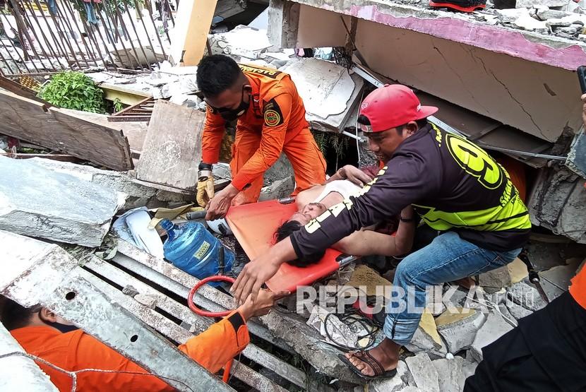 Petugas mengevakuasi korban yang terjepit bangunan di rumah sakit Mitra Manakarra yang runtuh akibat gempa bumi di Mamuju, Sulawesi Barat, Kamis (15/1/2021). sebanyak 5 orang dievakuasi dua diantaranya selamat dan tiga orang meninggal dunia di rumah sakit tersebut dan pencarian sementara masih berlanjut. 
