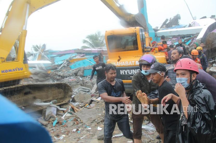 Petugas mengevakuasi korban yang terjepit dari bangunan di rumah sakit Mitra Manakarra yang runtuh akibat gempa bumi di Mamuju, Sulawesi Barat, Kamis (15/1/2021). Sebanyak tujuh korban berhasil dievakuasi, empat diantaranya selamat dan tiga lainnya meninggal dunia di reruntuhan rumah sakit tersebut. 