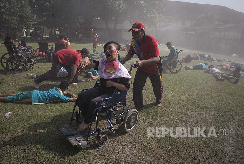 Petugas mengevakuasi pelajar berkebutuhan khusus saat simulasi penanganan korban bencana angin puting beliung di Sekolah Luar Biasa (SLB) N 1 Bantul, DI Yogyakarta, Jumat (14/10). 