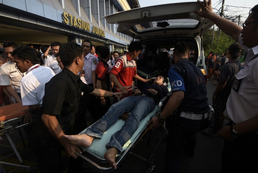 Petugas mengevakuasi penumpang yang menjadi korban tabrakan Kereta Rel Listrik (KRL) di Stasiun Juanda, Rabu (23/9).