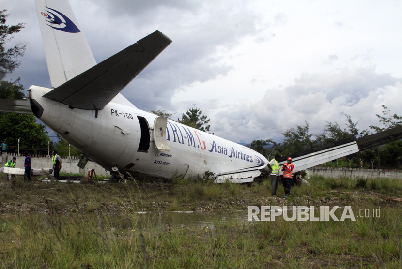 Petugas mengevakuasi pesawat kargo jenis boeing 737-301F dengan kode lambung PK-YGG milik maskapai penerbangan Tri-MG Asia Airlines yang tergelincir di Bandara Wamena, Wamena, Papua, Selasa (18/7). 