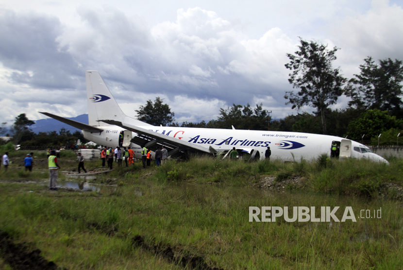Petugas mengevakuasi pesawat kargo jenis boeing 737-301F dengan kode lambung PK-YGG milik maskapai penerbangan Tri-MG Asia Airlines yang tergelincir di Bandara Wamena, Wamena, Papua, Selasa (18/7).