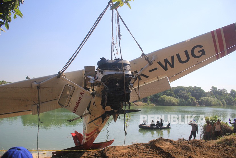 Petugas mengevakuasi pesawat latih yang jatuh di sungai Cimanuk, Indramayu, Jawa Barat, Selasa (23/7/2019). 