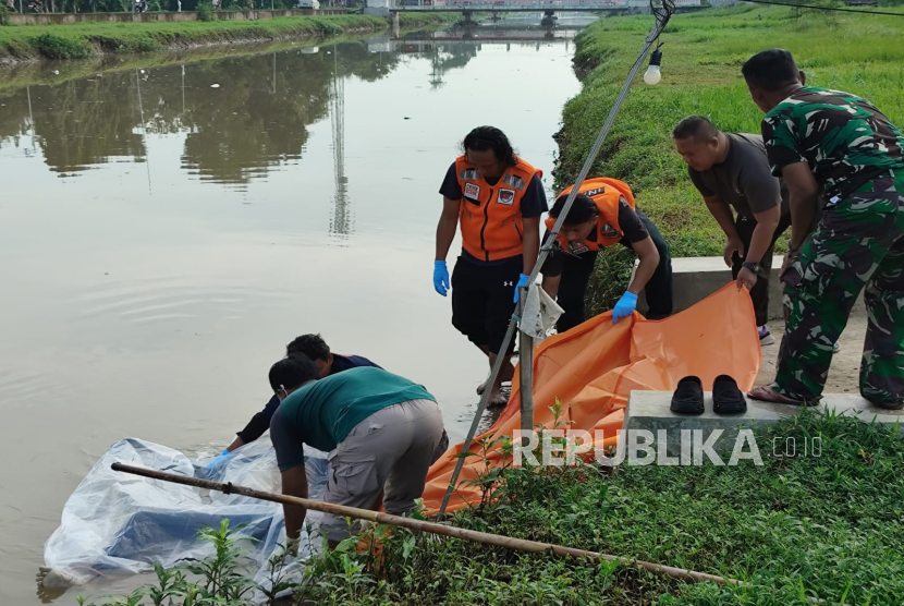 Petugas mengevakuasi sesosok mayat tanpa identitas yang ditemukan mengapung di aliran Sungai Sindupraja, Desa Sukagumiwang, Kecamatan Sukagumiwang, Kabupaten Indramayu, Jumat (14/2/2024). 