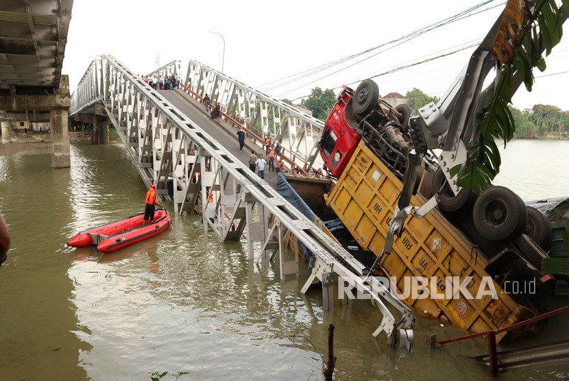 Petugas mengevakuasi truk di lokasi jembatan Widang yang runtuh, Tuban, Jawa Timur, Selasa (17/4). 