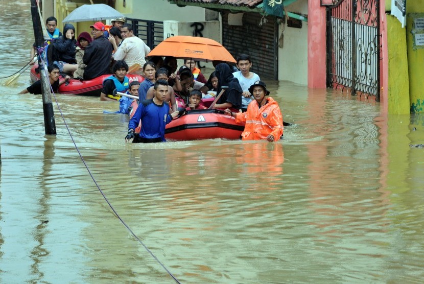 Petugas mengevakuasi warga dari banjir yang melanda permukiman di Cawang, Jakarta Timur