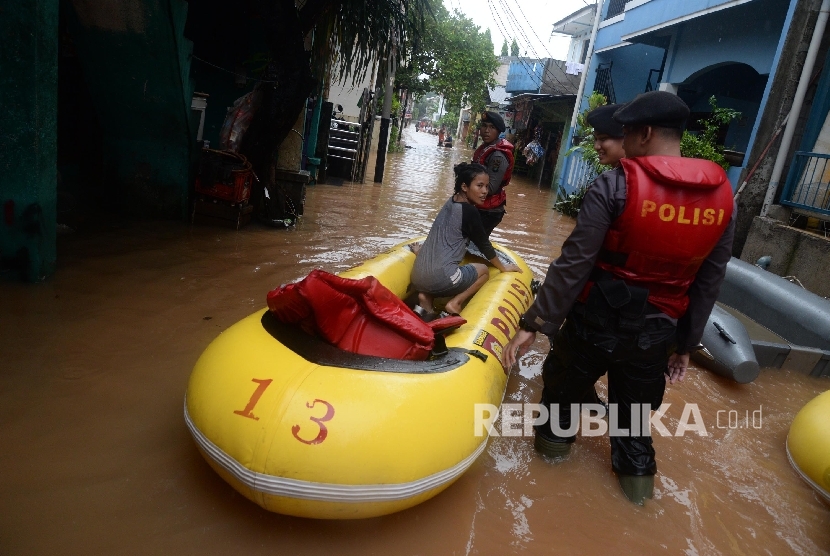 Petugas mengevakuasi warga denga perahu karet saat banjir melanda Kelurahan Cipinang Melayu, Kecamatan Makassar, Jakarta Timur, Senin (20/2). 