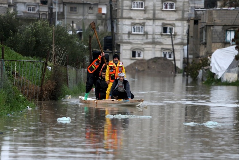 Petugas mengevakuasi warga di wilayah banjir di Jalur Gaza, Palestina, Selasa (26/1). 