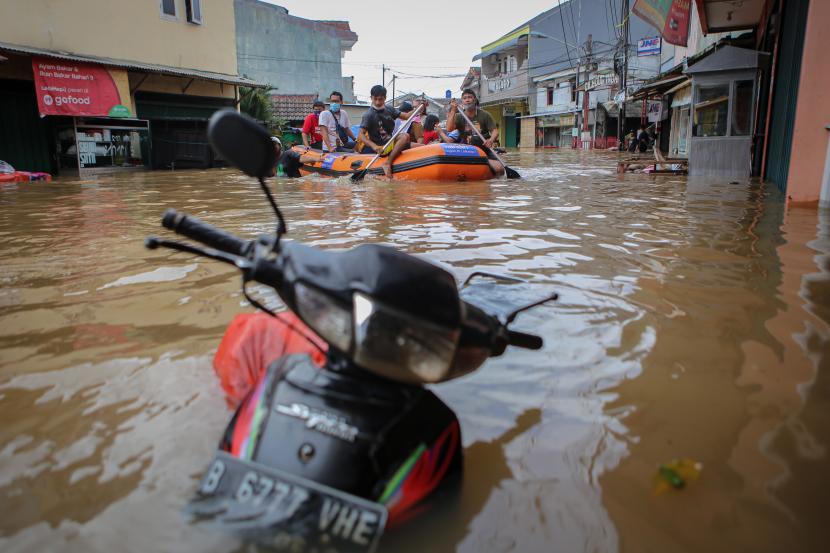 Petugas mengevakuasi warga menggunakan perahu karet saat banjir di Ciledug Indah, Kota Tangerang, Banten, Sabtu (20/2/2021).