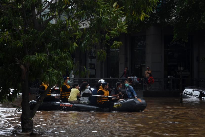 Petugas mengevakuasi warga menggunakan perahu karet saat banjir di kawasan Kemang, Jakarta Selatan, Sabtu (20/2/2021). Banjir yang terjadi akibat curah hujan tinggi serta drainase yang buruk membuat kawasan Kemang banjir setinggi 1,5 meter.