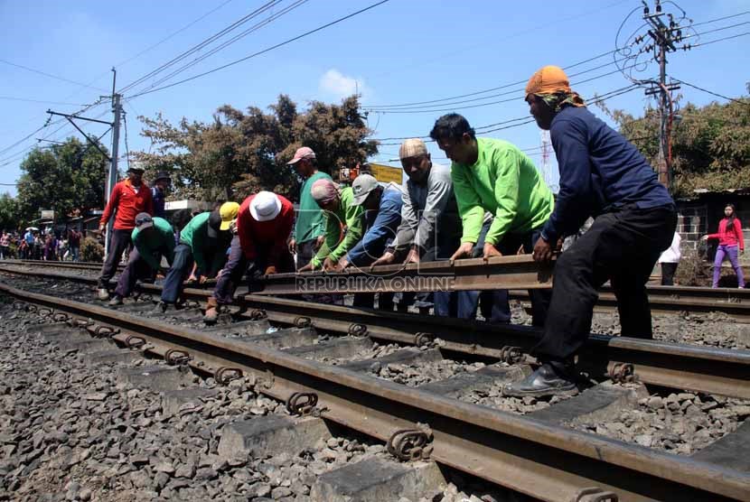 Petugas mengganti rel kereta api yang rusak akibat tabrakan kereta api dengan truk tangki di perlintasan kereta di Bintaro Permai, Jakarta Selatan, Selasa (10/12).   (Republika/Yasin Habibi)
