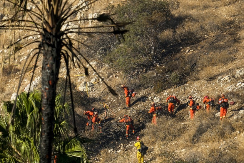Petugas menggarap batas api di perbukitan di West Hills, Kalifornia, (12/11). Kebakaran hutan menghabiskan lahan seluas puluhan hektare.