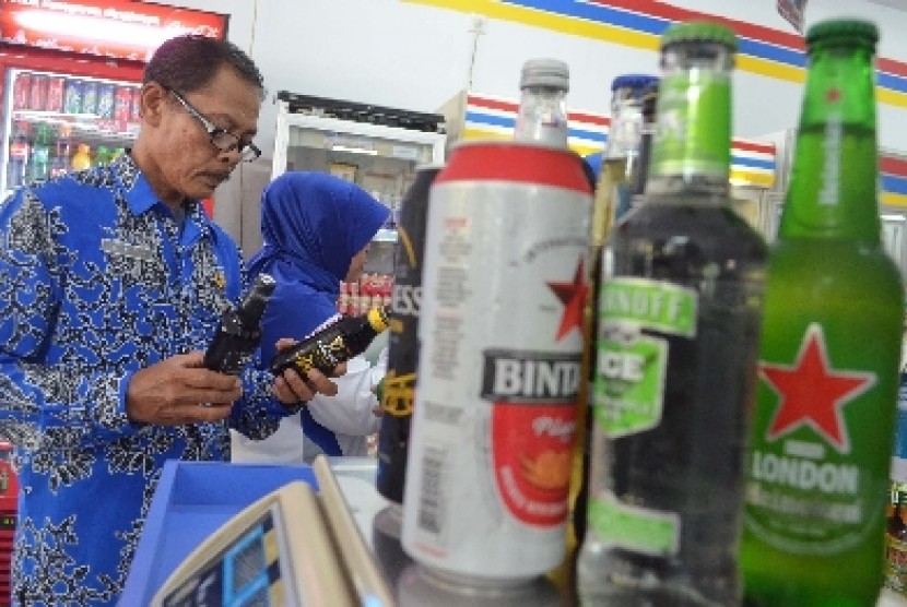 Petugas menggelar razia minuman beralkohol di sebuah minimarket di Kota Madiun, Jumat (30/1).