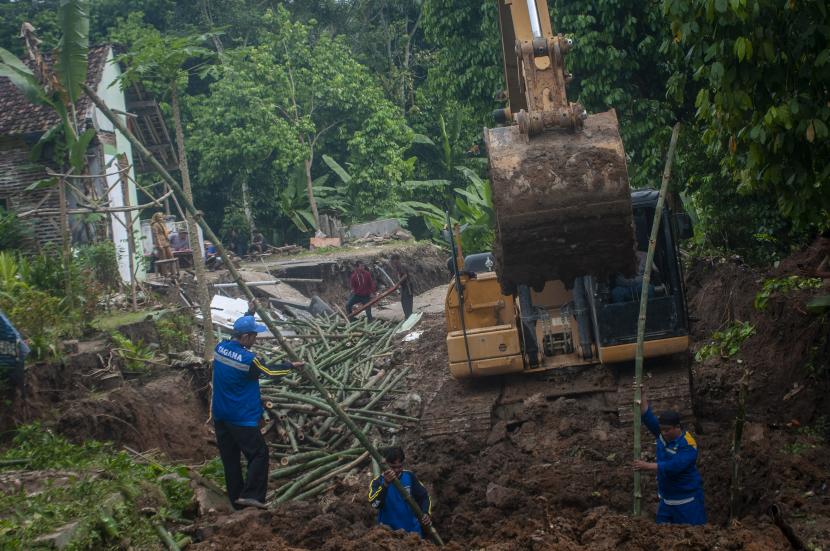 Petugas menggunakan alat berat membangun pondasi jalan darurat akibat bencana alam di Desa Cilangkap, Kabupaten Lebak, Provinsi Banten, Senin (13/6/2022).