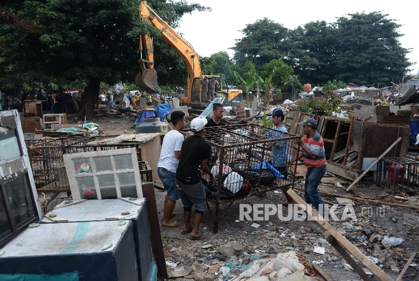 Petugas menggunakan kendaraan alat berat saat membongkar bangunan liar di kawasan TPU Menteng Pulo, Jakarta Selatan, Kamis (7/4).  (Republika/Yasin Habibi)