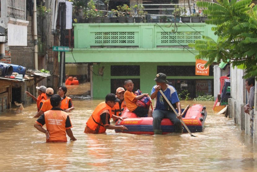 Petugas menggunakan perahu karet membawa warga melewati banjir yang merendam di kawasan Rawajati Kalibata, Jakarta, Selasa (8/3).