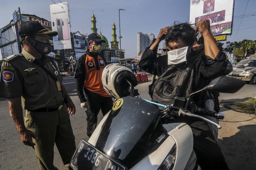 Petugas menghimbau pengendara untuk memakai masker saat Sosialisasi Gerakan Bermasker di Jalan Raya Margonda, Depok, Jawa Barat.