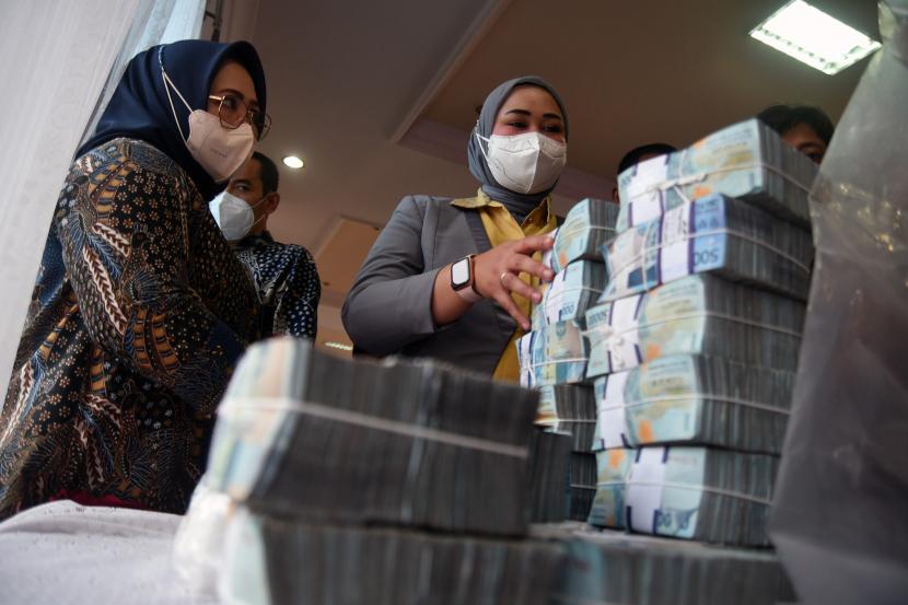 Petugas menghitung jumlah uang saat penyerahan barang bukti tindak pidana dana Bantuan Operasional Sekolah (BOS) di Aula Kejaksaan Negeri Bogor.